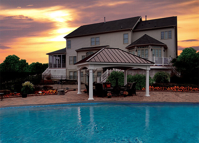 pergola next to a pool at sunset