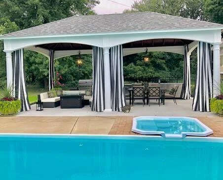 pavilion with drape curtains next to a pool