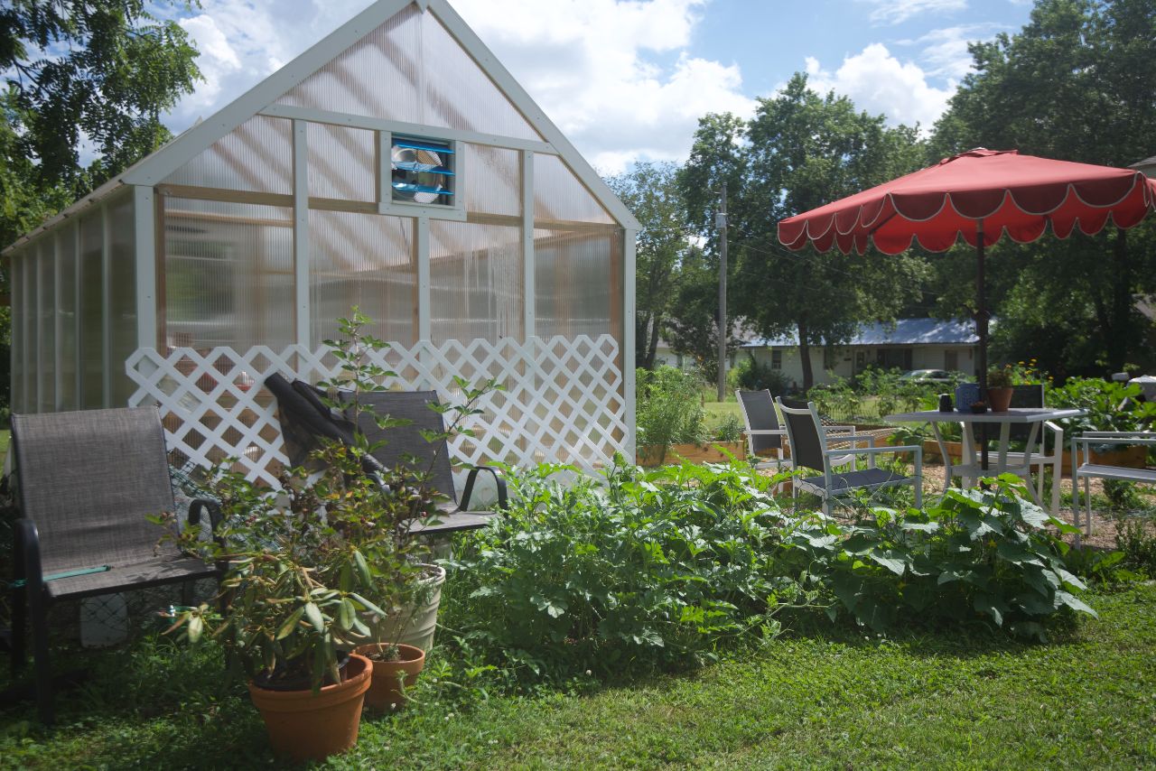 Greenhouse next to an outdoor furniture set