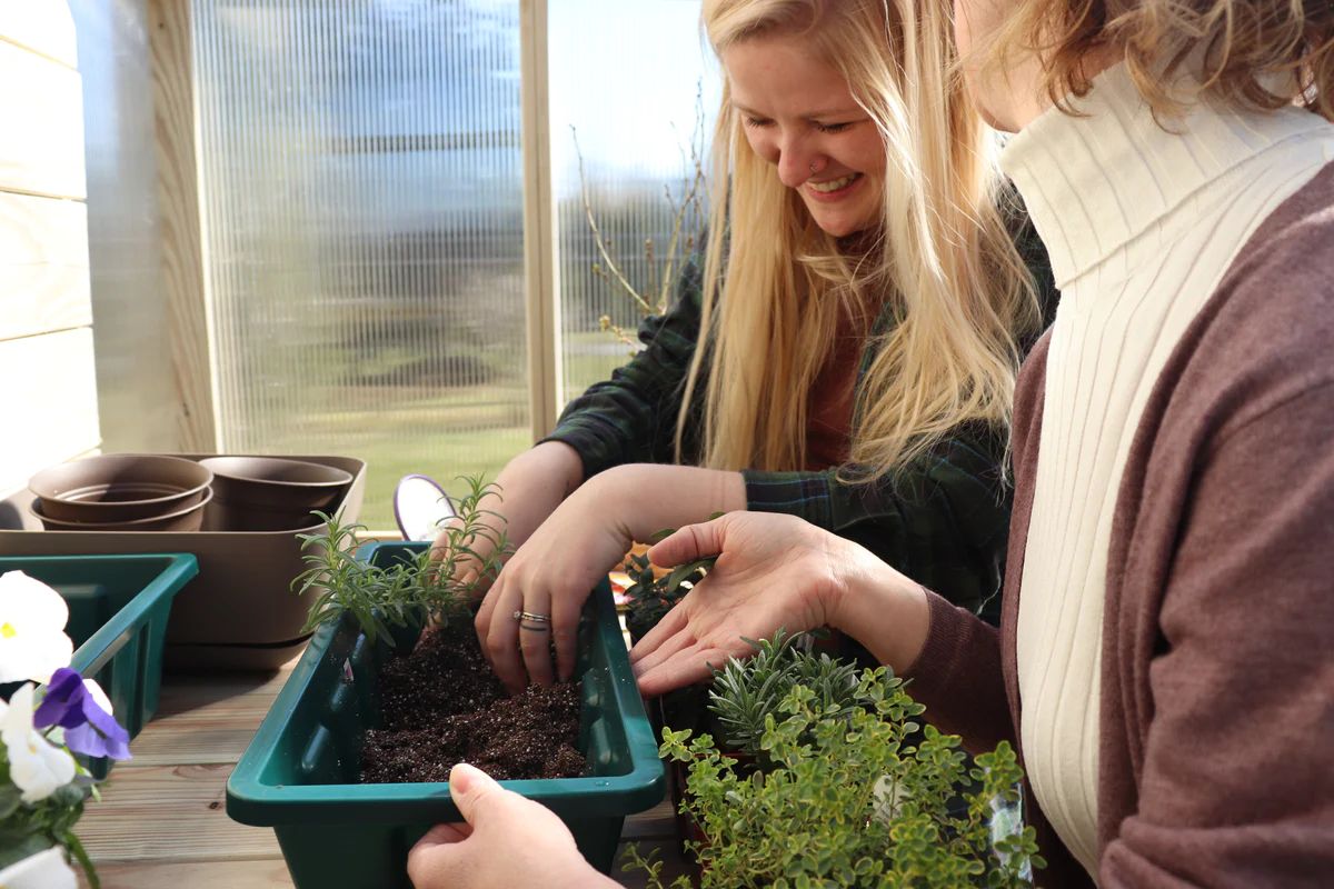 Women gardening inside an EZ Greenhouse